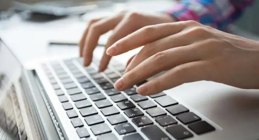 Profissional digitando em notebook durante consultoria de marketing digital com parceiro da RD Station.