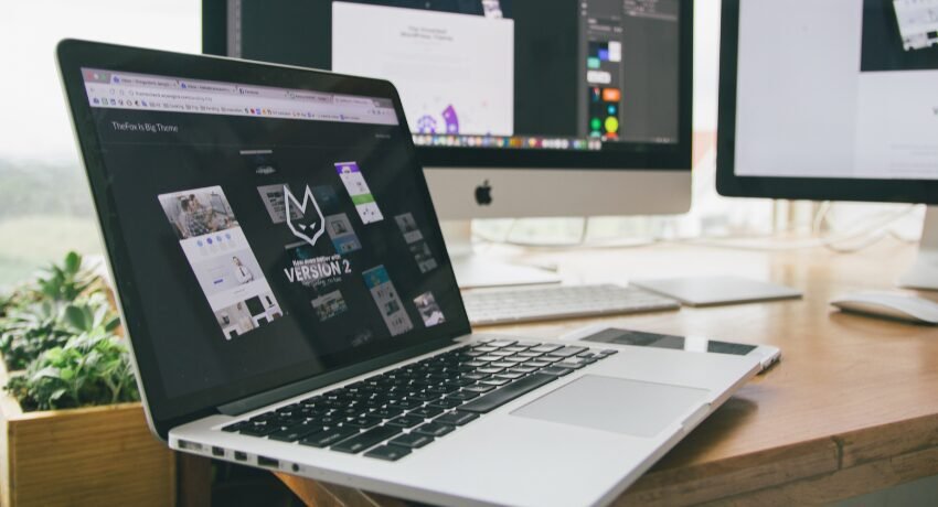 Ambiente de trabalho com notebook e monitores usado para testar e otimizar site responsivo