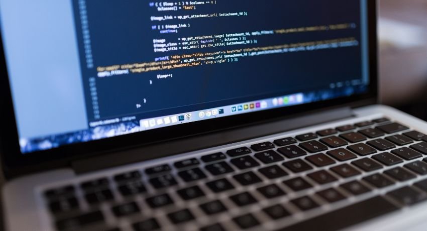 Tela de notebook exibindo linhas de código de programação em editor de texto.