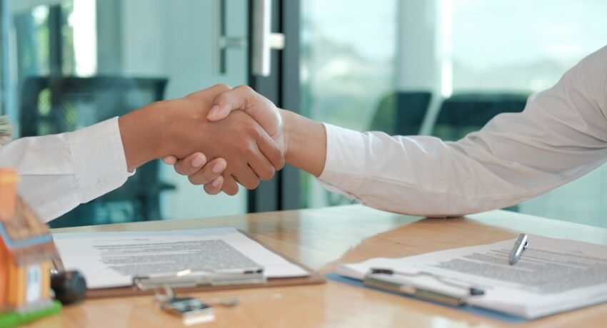 Aperto de mãos durante negociação imobiliária de alto padrão, simbolizando confiança na compra de apartamento no Jardins.