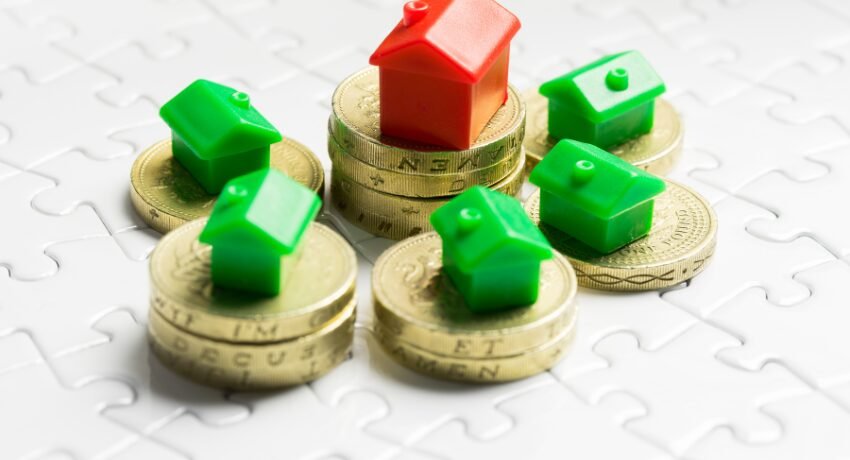 Casas em miniatura sobre moedas representando investimentos no mercado imobiliário de luxo em Miami